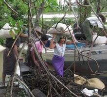 受け取った種籾をボートまで運ぶ。デルタ地帯では同じ村の中でも移動や輸送にボートは必須