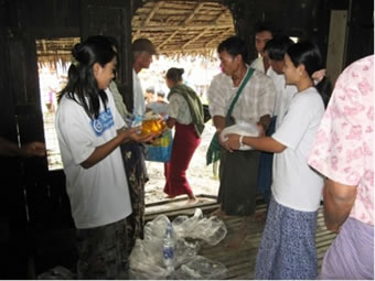 村の住民にも協力してもらいながら物資を配布するセンタースタッフ（右）と研修生OB（左）