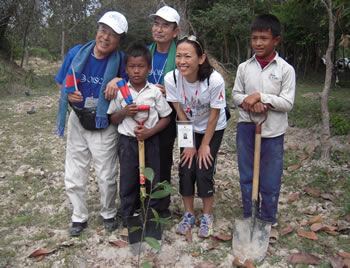 有森さん（右から2番目）と一緒に記念撮影する植林参加者