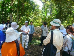 プロジェクト開始から11年目を迎えた森で、住民意識の変化を語る吉永所長（中央左白い帽子）