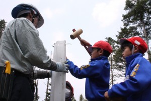 森林組合の方々の指導を受けながら、自分の背より高い杭を打ち込む児童たち