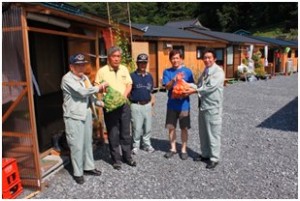 住田町町長（左から2番目）、仮設住宅団地入居者（右から2番目）にジャガイモを手渡す丹波山村関係者