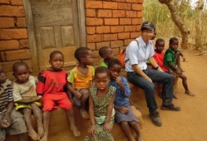 調査対象地の村で子どもたちに囲まれる長（マラウイ） 