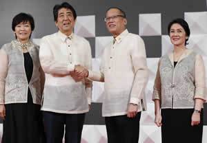 オイスカのネグロスシルクが使用されたバロンタガログを着る安倍首相夫妻とアキノ大統領（AFP＝時事）