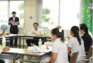 研修生らと意見交換をする浜田知事（左から2 人目）。食品加工研修の成果の一つであるシフォンケーキを賞味しみながらの懇談となった